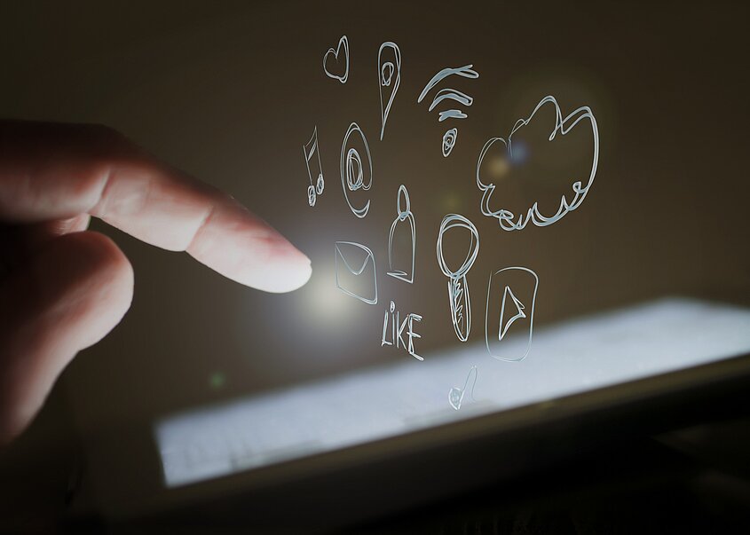 Digitalisierung Hotellerie: Ein Finger tippt virtuell auf ein Tablett und Wolken kommen aus dem Tablett heraus